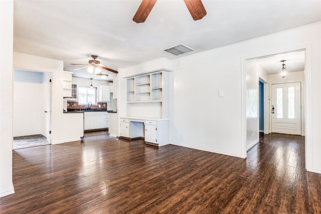 Unfurnished living room with a ceiling fan, dark wood-style flooring, a sink, and baseboards | Image 21