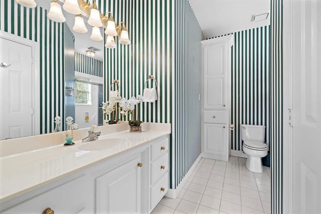 En suite bathroom has plenty of natural light, classic fixtures, and clean lines. | Image 36