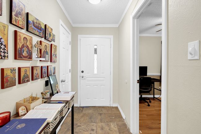 Foyer entrance with crown molding, a textured ceiling, and stone finish flooring | Image 17