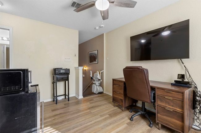 Home office with baseboards, ceiling fan, visible vents, and light wood-style floors | Image 17