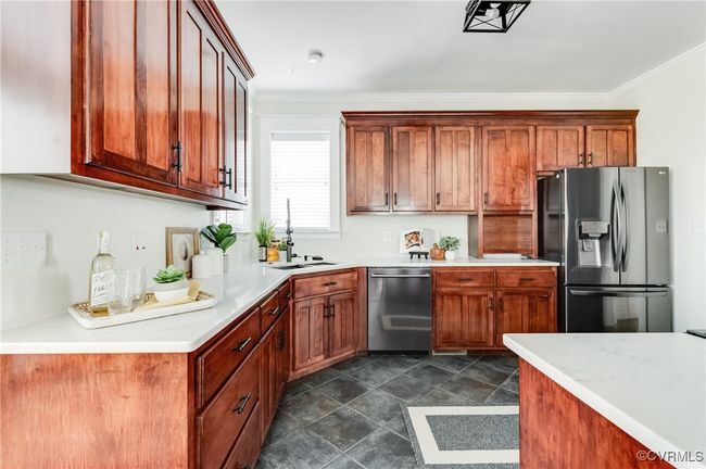 Kitchen with light countertops, a sink, ornamental molding, and appliances with stainless steel finishes | Image 14