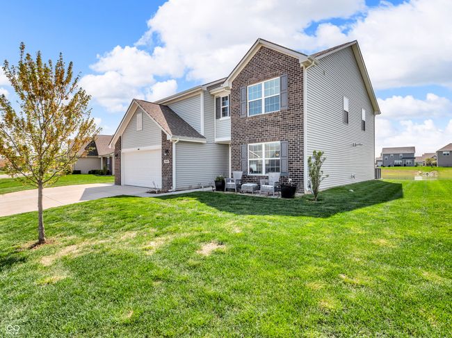traditional-style home with a garage, brick siding, a front lawn, and concrete driveway | Image 39