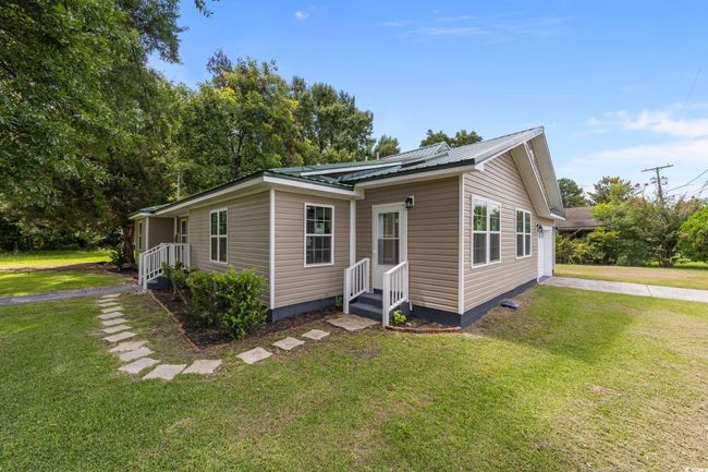 View of front of home featuring a front lawn and a metal roof | Image 5