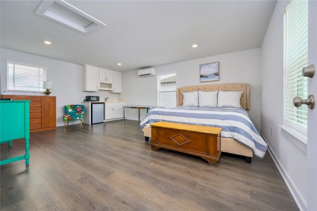 Efficiency apartment above garage with dark wood finished floors, refrigerator, attic access, and recessed lighting | Image 23