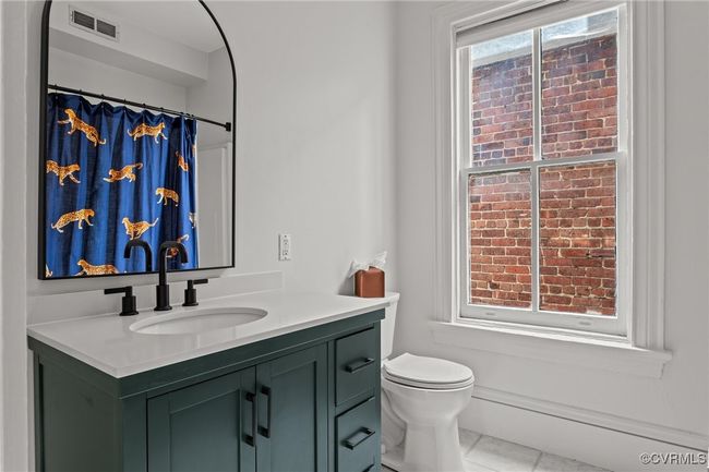 Bathroom featuring visible vents, toilet, vanity, and tile patterned floors | Image 30