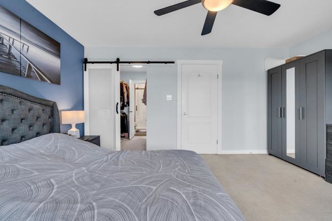 Bedroom with a barn door, baseboards, carpet floors, and ceiling fan | Image 21