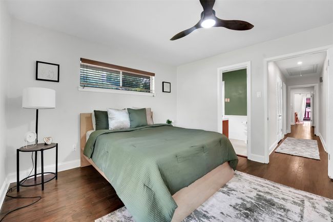 Bedroom featuring attic access, wood finished floors, ensuite bathroom, and ceiling fan | Image 13