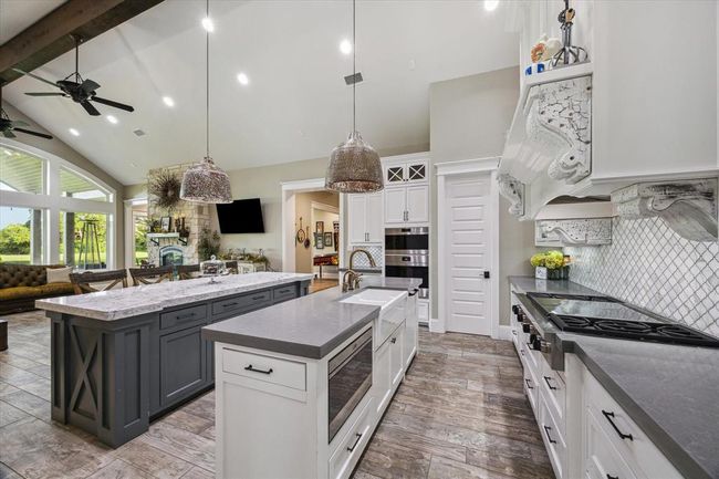 The kitchen is equipped with a hands-free garbage disposal for added convenience, a sleek drawer microwave for space-saving efficiency, and a three-tray dishwasher, ensuring both practicality and seamless organization. | Image 9