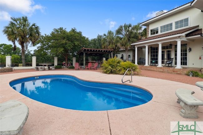 What a great place to enjoy family time! With an abundance of seating, both on the porch, pool area, and the outdoor kitchen area. Even the cook can take part in the fun. | Image 42