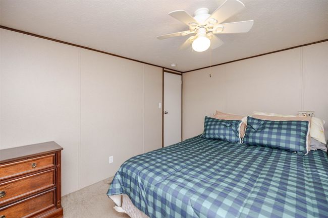 Bedroom with ornamental molding, a ceiling fan, carpet flooring, and a textured ceiling | Image 10