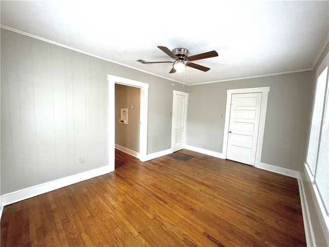 Unfurnished room with wood finished floors, a ceiling fan, baseboards, and ornamental molding | Image 7