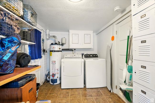 Laundry room with water heater, independent washer and dryer, and a textured ceiling | Image 17