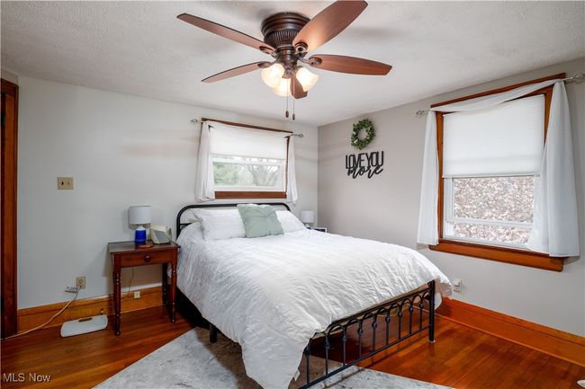 Bedroom with hardwood / wood-style floors, baseboards, and ceiling fan | Image 20