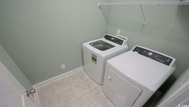Laundry area featuring washing machine and clothes dryer and baseboards | Image 18