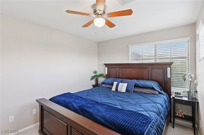 Bedroom with light colored carpet, baseboards, and ceiling fan | Image 43