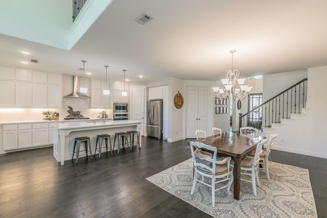 Dining area featuring recessed lighting, a chandelier, dark wood-type flooring, and stairway | Image 6