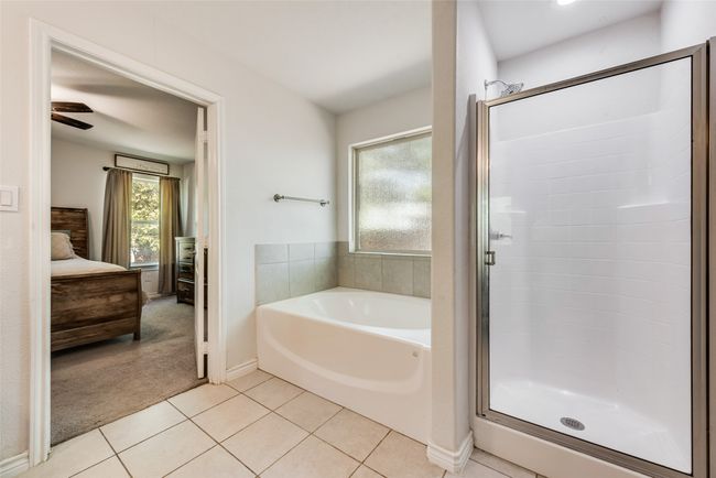 Full bathroom featuring a bath, a stall shower, ensuite bath, and tile patterned flooring | Image 26