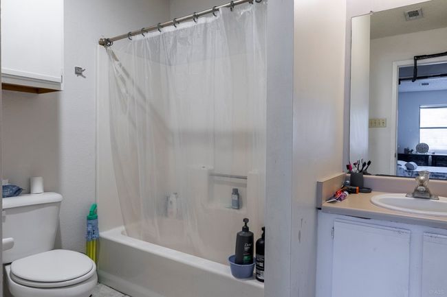 Full bathroom featuring toilet, vanity, and shower / bathtub combination with curtain | Image 24