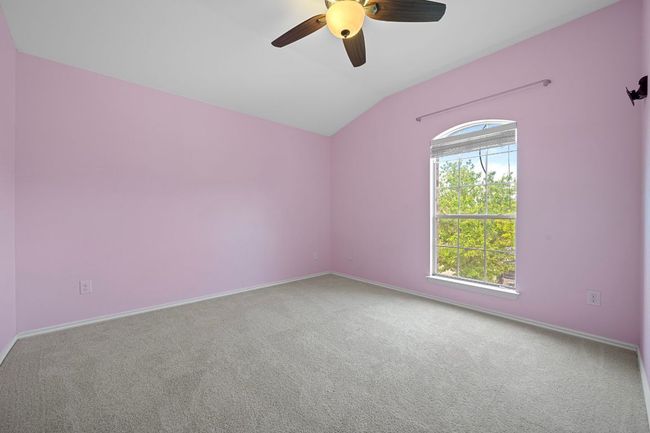 Carpeted spare room with vaulted ceiling, ceiling fan, and baseboards | Image 24
