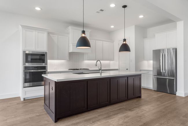Kitchen with stainless steel appliances, light countertops, a sink, backsplash, and recessed lighting | Image 24