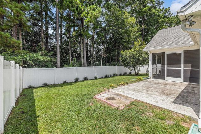 Fenced backyard featuring a sunroom, a patio area, and view of wooded area | Image 33