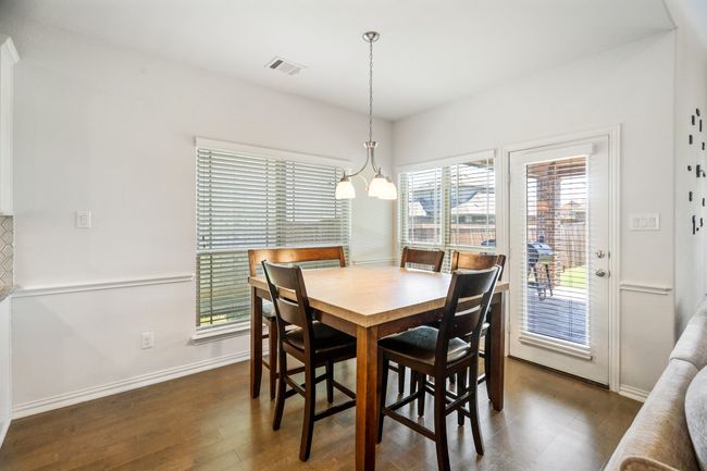 Dining room with dark wood-style flooring and a chandelier | Image 16