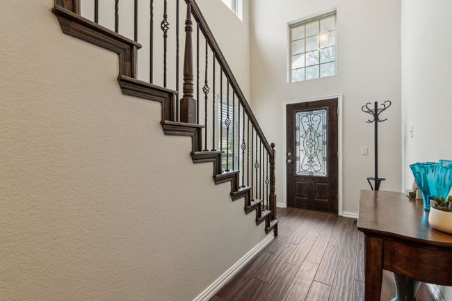 Foyer entrance with baseboards, stairway, dark wood finished floors, and a high ceiling | Image 11