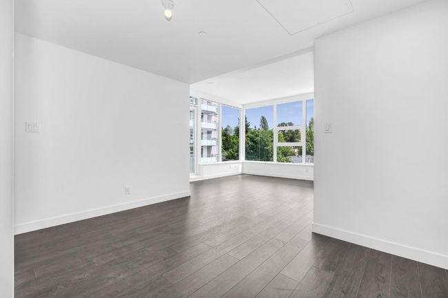 Empty room with dark wood finished floors and attic access | Image 6