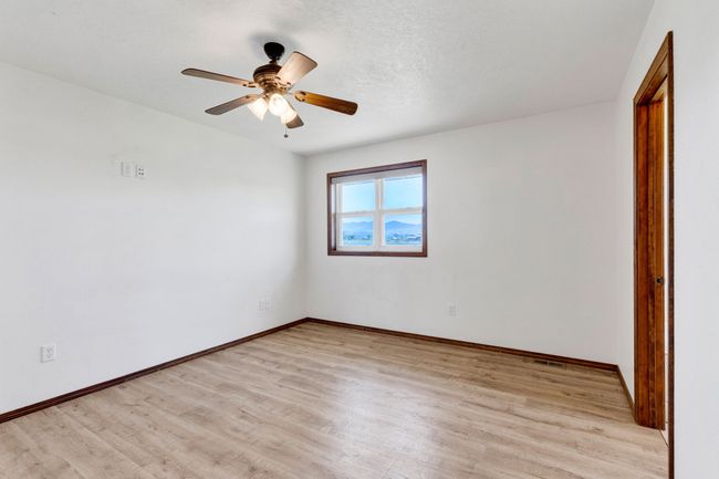 Bedroom featuring light wood-style flooring, baseboards, and a ceiling fan | Image 33