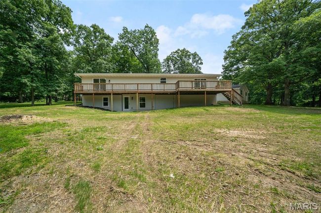 Rear view of property featuring a deck, stairway, and a lawn | Image 52