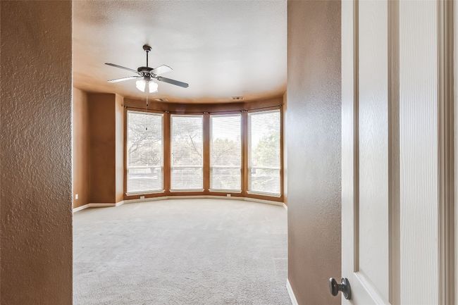 Empty room featuring carpet floors, a textured wall, and ceiling fan | Image 20