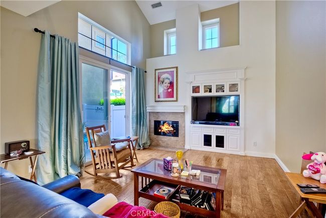 Living room with warming fireplace, custom entertainment center, sliding doors lead to outdoor patio | Image 16