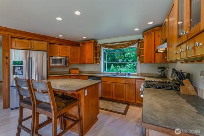 Spacious kitchen with ample cabinets and counter space. Stainless steel appliances, including propane range. | Image 8