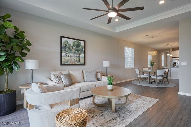 Living area with ceiling fan with notable chandelier, recessed lighting, baseboards, and wood finished floors | Image 4