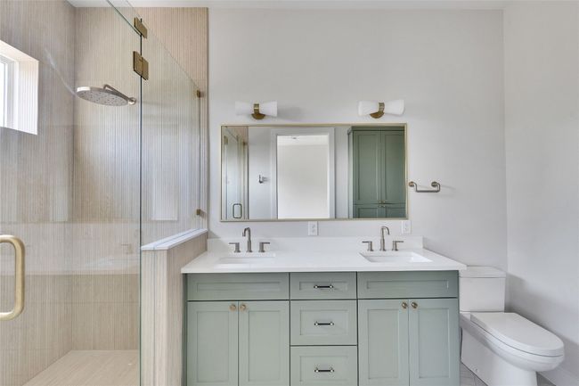 Full bath featuring a shower stall, toilet, and double vanity | Image 28