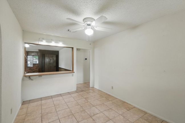 Spare room with a ceiling fan, a textured ceiling, baseboards, and tile patterned floors | Image 15