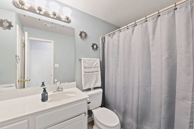 Full bathroom featuring vanity, a textured wall, and a textured ceiling | Image 14