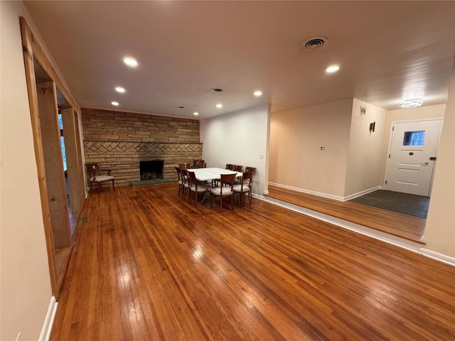 Living area featuring a stone fireplace, dark wood-style floors, visible vents, and recessed lighting | Image 4