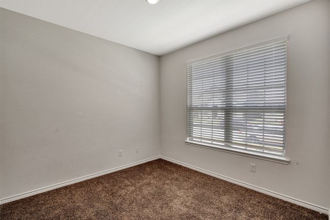 Spare room featuring dark colored carpet and baseboards | Image 15