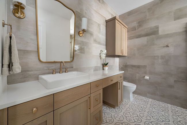 Bathroom with tile patterned floors, vanity, toilet, and tile walls | Image 22