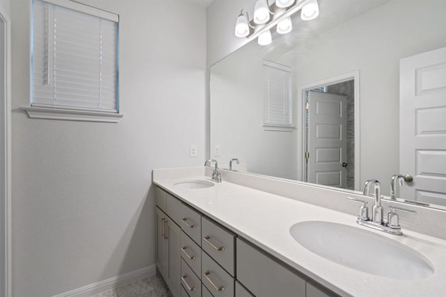 Bathroom featuring marble finish floor, baseboards, double vanity, and a sink | Image 29