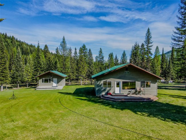 Back of property with a wooded view, a lawn, and a wooden deck | Image 80