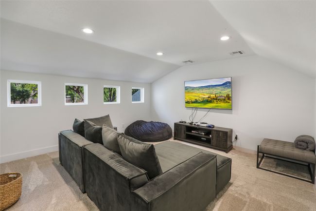 Carpeted living room featuring baseboards, vaulted ceiling, visible vents, and recessed lighting | Image 30