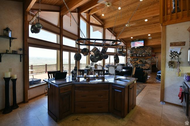 Kitchen with wood ceiling, dark countertops, a sink, and high vaulted ceiling | Image 73
