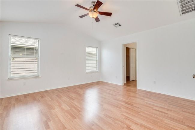 The upstairs primary bedroom is very spacious and features French doors, a new ceiling fan, and direct access to the primary bathroom. | Image 12