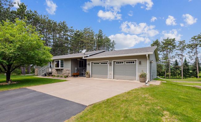 Attractive curb appeal with a clean concrete and asphalt driveway surrounded by mature trees and nice landscaping. | Image 4