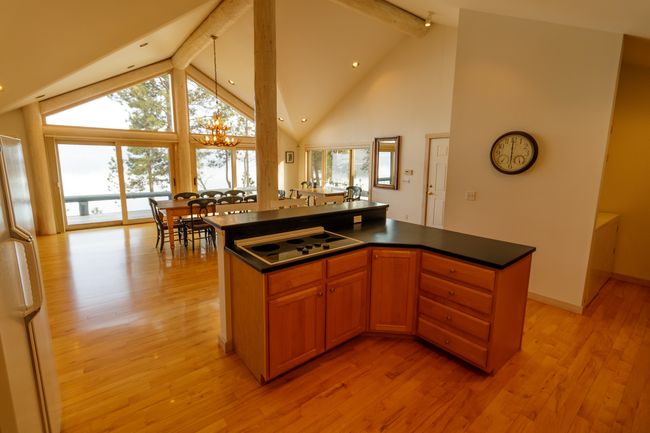 Kitchen featuring a kitchen island, stainless steel cooktop, beam ceiling, and light hardwood / wood-style flooring | Image 22