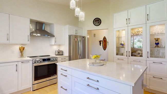 Kitchen featuring glass insert cabinets and white cabinets | Image 6