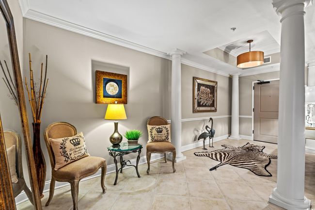 Sitting room featuring ornate columns, ornamental molding, a raised ceiling, and tile patterned floors | Image 5