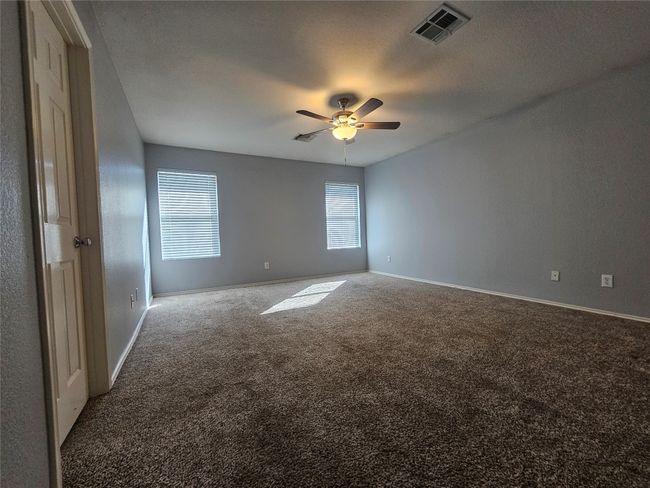 Carpeted spare room featuring ceiling fan and baseboards | Image 14